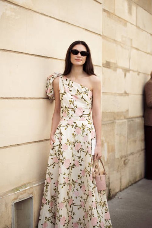 Guest wears long white dress with flowers and sunglasses outside Giambattista Valli fashion show during the Womenswear Fall/Winter 2025/2026 as part...