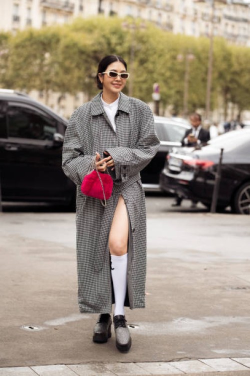 Guest wears long white socks, white top, grey checkered coat, red bag and loafers outside the Stella McCartney show during Womenswear Spring/Summer...