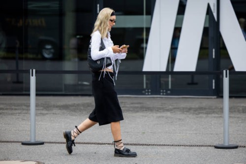 Guest wears navy blazer, Miu Miu bag, knee high socks outside Lueder during the Berlin Fashion Week SS25 on July 01, 2024 in Berlin, Germany.