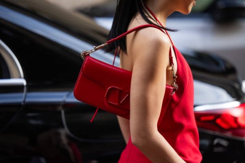 Guest wears red bag, dress outside Valentino during the Womenswear Fall/Winter 2024/2025 as part of Paris Fashion Week on March 03, 2024 in Paris,...