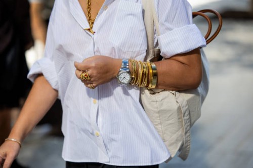 Guest wears Rolex Daydate, golden bracelets outside Toteme during New York Fashion Week on September 10, 2024 in New York City.
