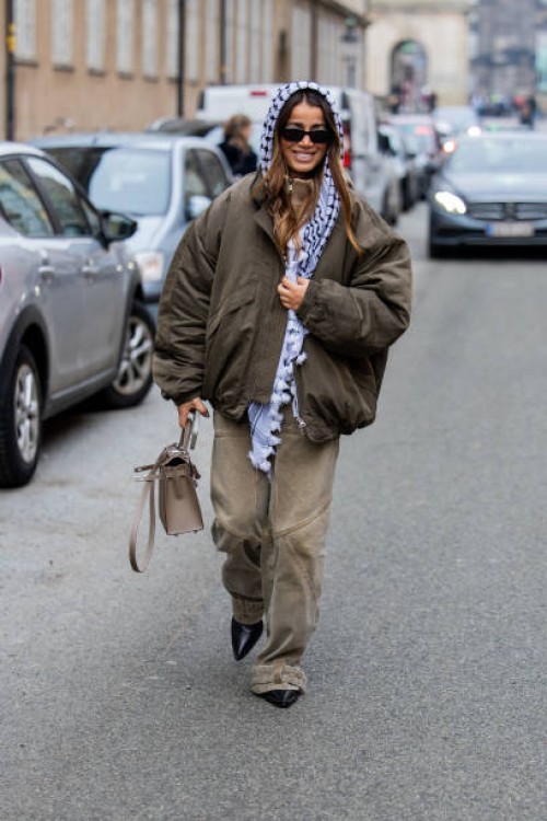 Guest wears scarf, bomber jacket, beige pants, Hermes bag outside Lovechild 1979 during the Copenhagen Fashion Week AW24 on January 30, 2024 in...