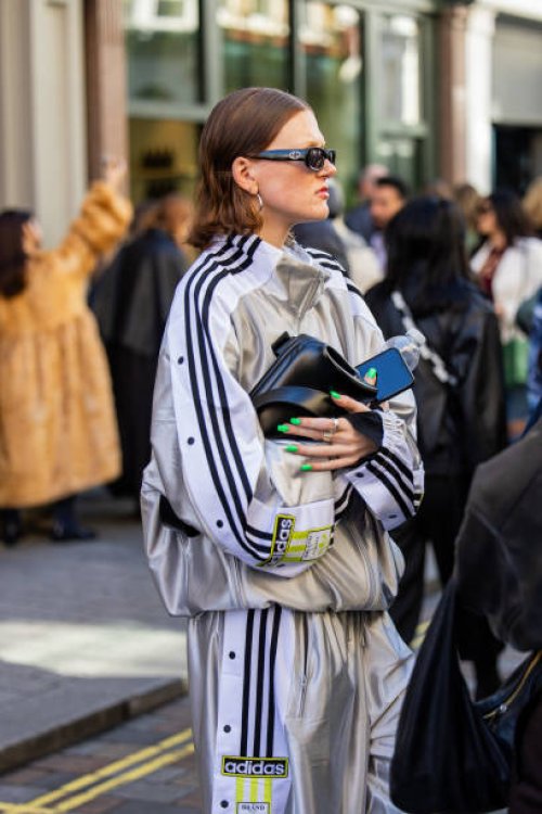 Guest wears silver Adidas track suit, black bagoutside Bora Aksu during London Fashion Week September 2024 on September 13, 2024 in London, England.