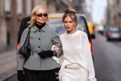 Guest wears sunglasses , a black turtleneck, a black and white oversized houndstooth pattern printed jacket with puff sleeves ; a guest wears a...