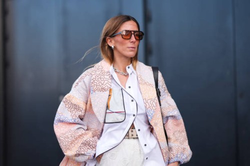Guest wears sunglasses, a white shirt, a pastel pale floral print flowing oversized light jacket , a beige studded belt, outside Munthe, during the...