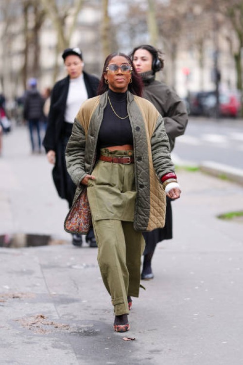 Guest wears transparent glasses, silver hoop earrings, black turtleneck long sleeve cropped shirt, silver chain necklace, dark green high waisted...