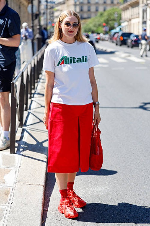 Guest wears white Alitalia printed t-shirt, red bermuda, red bag, red socks, red sneakers, outside Craig Green, during the Menswear Spring/Summer...