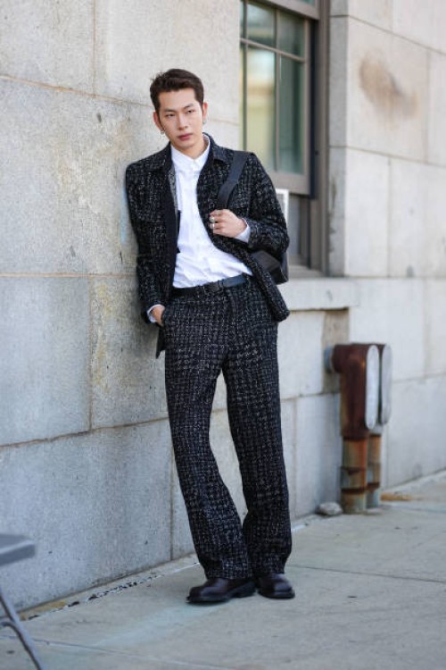 Guest wears white buttoned up long sleeve shirt, black gray pattern jacket, black gray pattern pants, black leather belt, silver rings, shiny black...