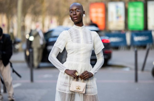 Guest wears white laced transparent dress, bagoutside Georges Hobeika during the Womenswear Fall/Winter 2025/2026 as part of Paris Fashion Week on...