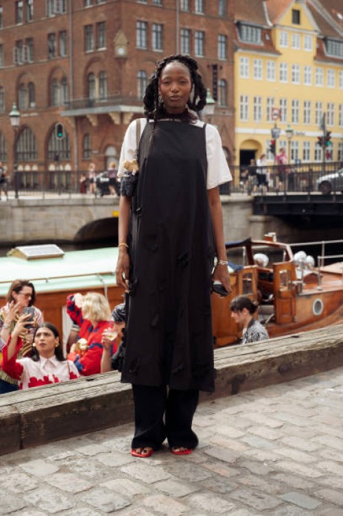 Guest wears white shirt and black dress at VIP guest trip with a boat to the Marimekko show during day four of the Copenhagen Fashion Week SS25 on...