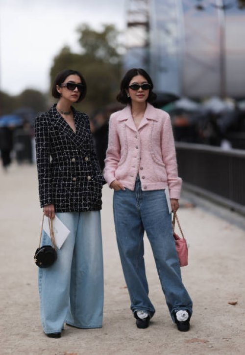 Guests are seen outside Chanel show wearing black Chanel sunnies, rose tweed Chanel jacket, black and white checkered tweed Chanel blazer, oversized...