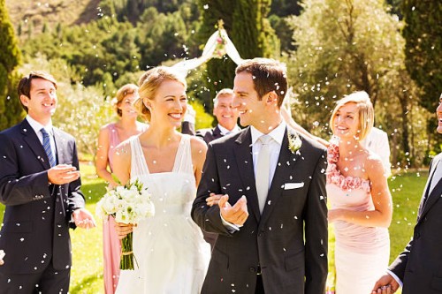 guests throwing confetti on couple during garden wedding - garden decoration stock pictures, royalty-free photos & images