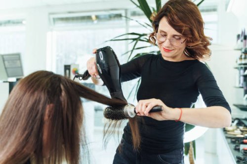 hair drying and combing female customer hair. stylish hairdresser cutting and drying woman hair in salon - hairstyle stock pictures, royalty-free photos & images