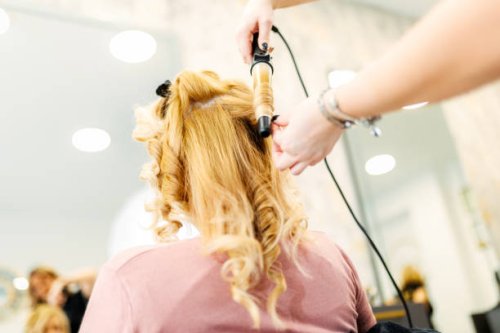 hairstylist using curling iron in salon - hairstyle stock pictures, royalty-free photos & images