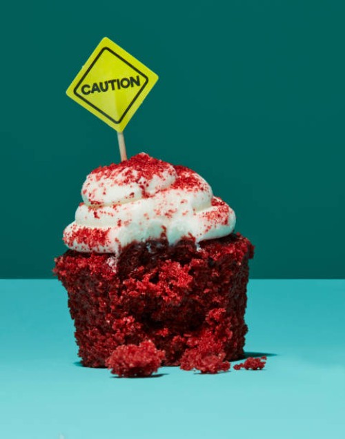 half eaten cupcake with caution sign - food stock pictures, royalty-free photos & images