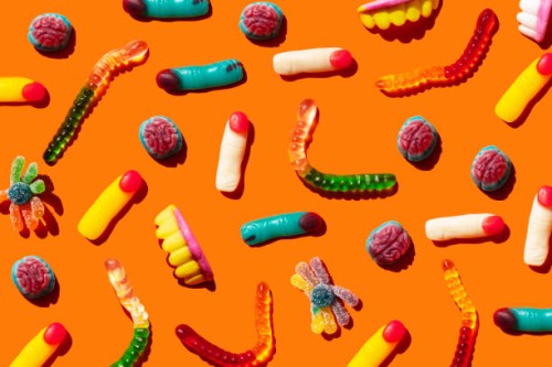 halloween jelly beans, finger-shaped, brains, worm and vampire teeth on orange background - junk food stock pictures, royalty-free photos & images