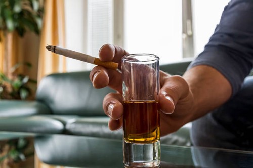 hand holding cigarette and shot glass - junk food stock pictures, royalty-free photos & images