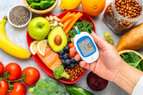 hand holding glucometer on healthy food background - food stock pictures, royalty-free photos & images