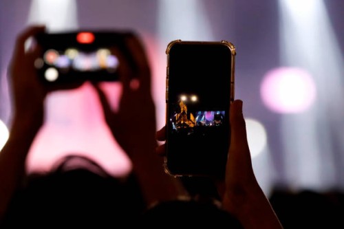 hand holding modern smartphone on a concert. - concert stock pictures, royalty-free photos & images