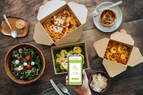 hand holding smartphone, takeaway food on dining table - junk food stock pictures, royalty-free photos & images