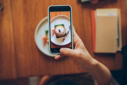 hand of an anonymous young woman taking a snapshot of her delicious looking pumpkin spice late in order to post it to social media - food stock pictures, royalty-free photos & images