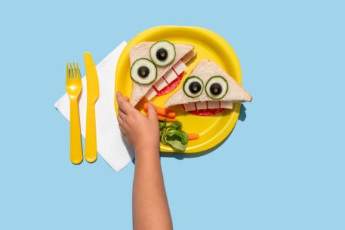 hand of baby girl picking up funny looking sandwich withanthropomorphic face - food stock pictures, royalty-free photos & images