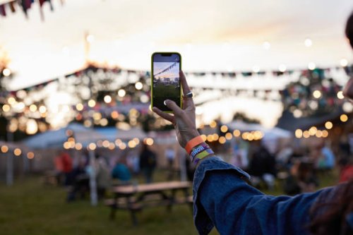 hand of woman photographing bunting through phone - concert stock pictures, royalty-free photos & images