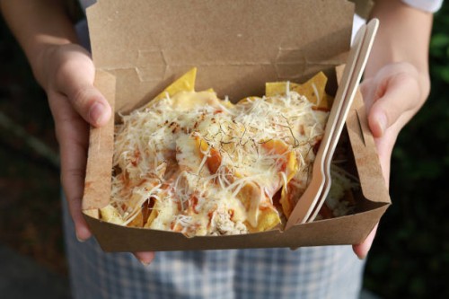hands holding a take away paper box of nachos with cheese - junk food stock pictures, royalty-free photos & images