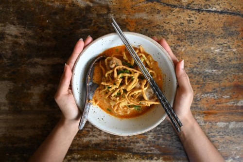 hands holding bowl of khao soi - food stock pictures, royalty-free photos & images