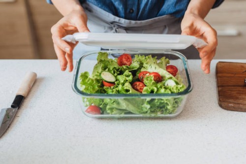 hands of a woman packing a healthy salad into a glass container to be taken away - food stock pictures, royalty-free photos & images