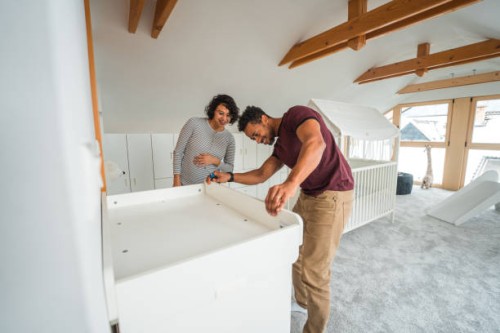 handsome latin american couple organizing a baby room - home decoration stock pictures, royalty-free photos & images