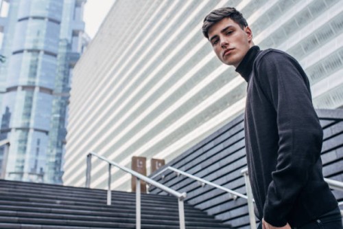 handsome man in black clothing standing on stairs - fashion stock pictures, royalty-free photos & images