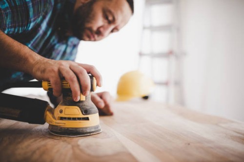handyman sanding a wood table. - home decoration stock pictures, royalty-free photos & images