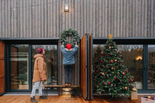 hanging a christmas wreath - garden decoration stock pictures, royalty-free photos & images