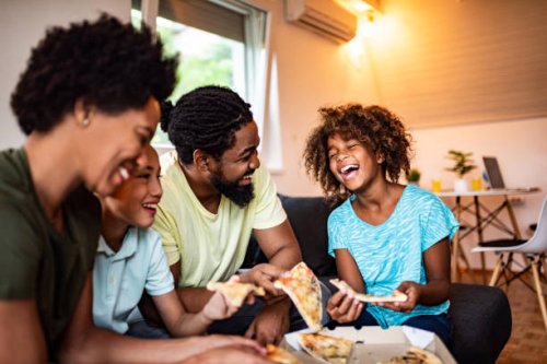 happy african american family eating pizza at home. - junk food stock pictures, royalty-free photos & images