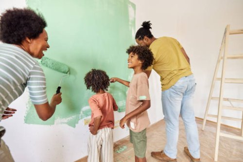 happy african american family talking while painting walls in their apartment. - home decoration stock pictures, royalty-free photos & images