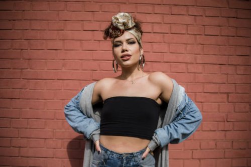 happy beautiful fashion hipster young woman smiling while posing in front of red brick wall - hairstyle stock pictures, royalty-free photos & images