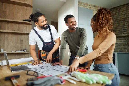 happy black couple and manual worker working on blueprints at home. - home decoration stock pictures, royalty-free photos & images