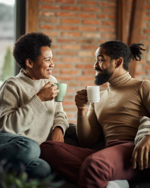 happy black couple talking during tea time at home. - coffee stockfoto's en -beelden