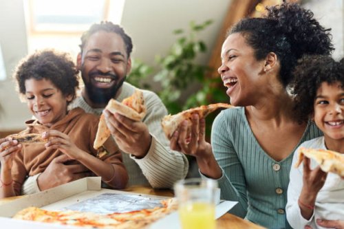 happy black family eating pizza for lunch in dining room. - junk food stock pictures, royalty-free photos & images