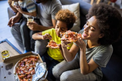 happy black family having pizza for lunch at home. - junk food stock pictures, royalty-free photos & images