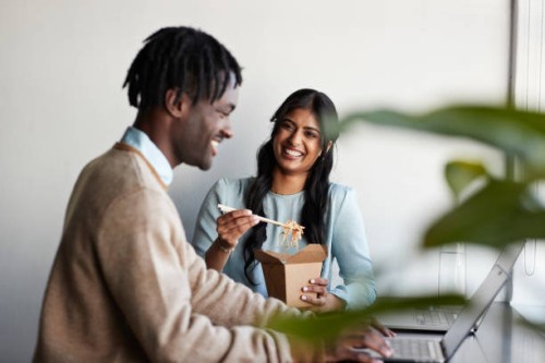 happy businesswoman discussing with businessman during break - junk food stock pictures, royalty-free photos & images