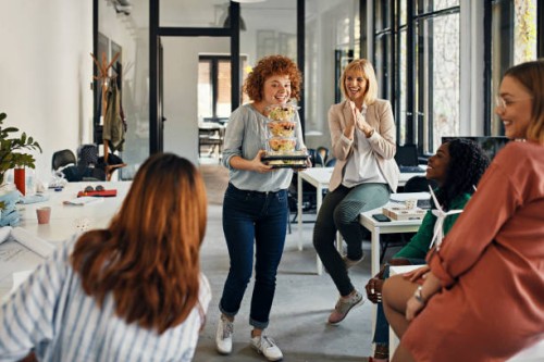 happy businesswoman serving takeaway food to colleagues in office - junk food stock pictures, royalty-free photos & images