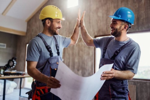 happy construction workers congratulating each other at renovating house. - home decoration stock pictures, royalty-free photos & images