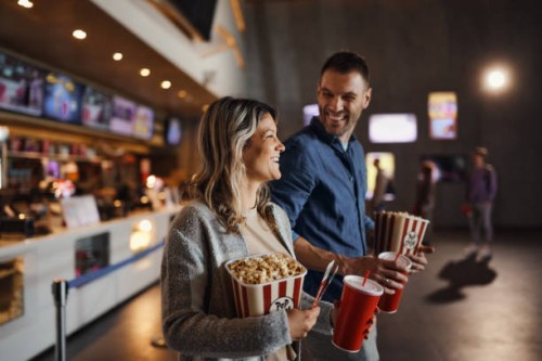 happy couple bought popcorn and drinks before movie projection in cinema. - food stockfoto's en -beelden