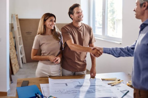 happy couple came to a successful deal with interior designer in the apartment. - home decoration stock pictures, royalty-free photos & images