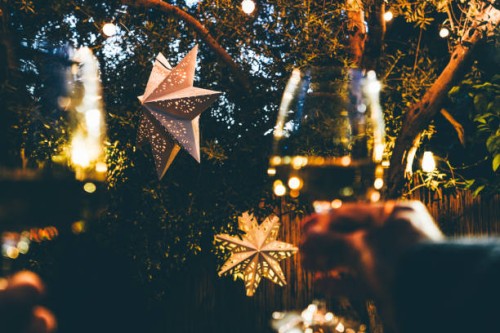 happy couple celebrate christmas with champagne against the backdrop of a christmas paper star in the backyard. - garden decoration stock pictures, royalty-free photos & images