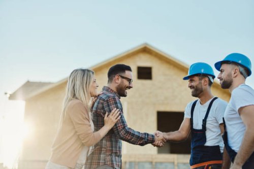 happy couple greeting manual workers in front of renovating house. - home decoration stock pictures, royalty-free photos & images