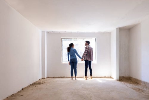 happy couple holding hands at a construction site while building their house - home decoration stock pictures, royalty-free photos & images