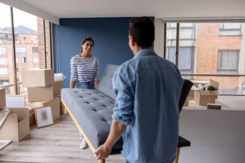 happy couple moving house and carrying a couch together - home decoration stock pictures, royalty-free photos & images